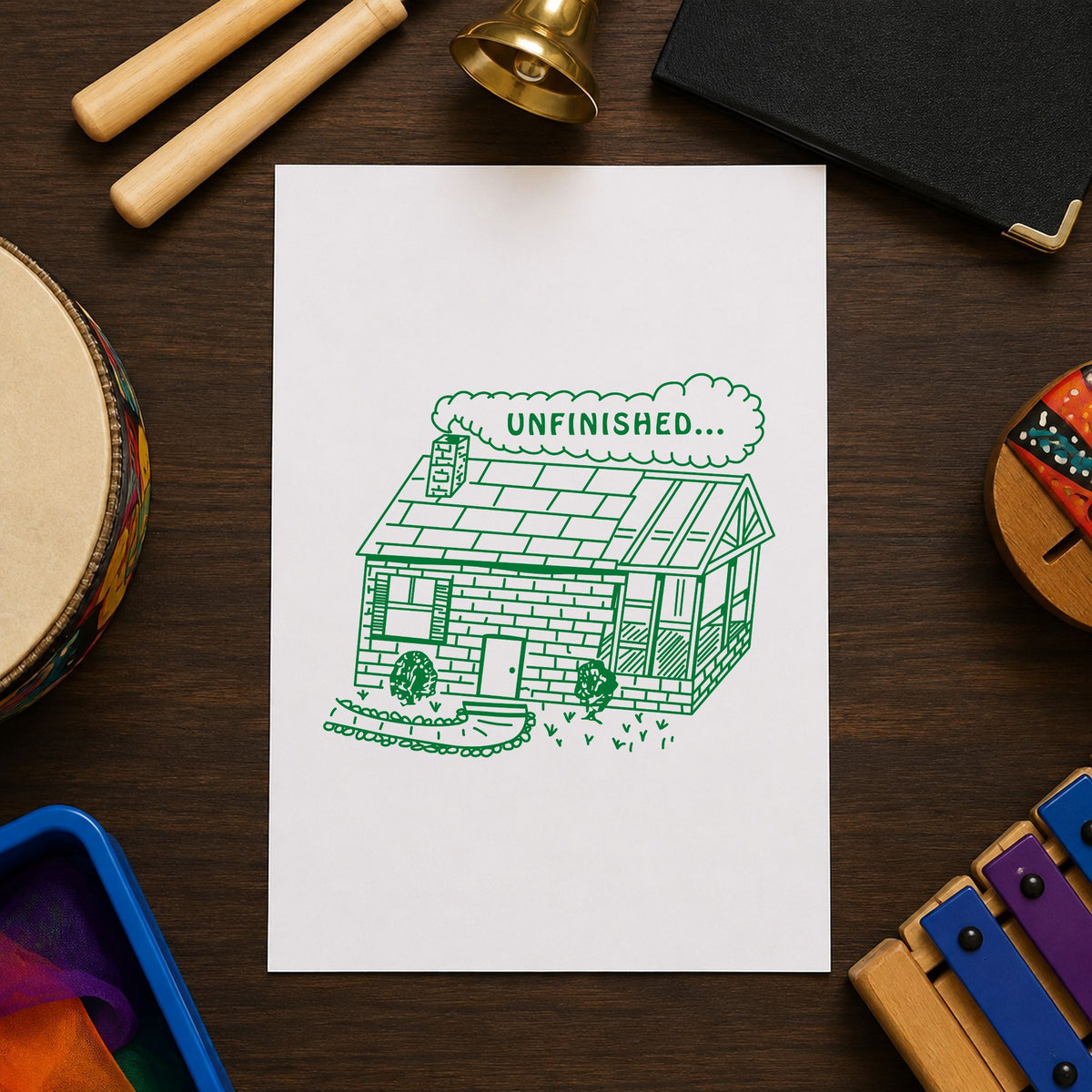Unfinished Work Reminder Rubber Stamp impression in green ink on white paper in a styled craft setting.
