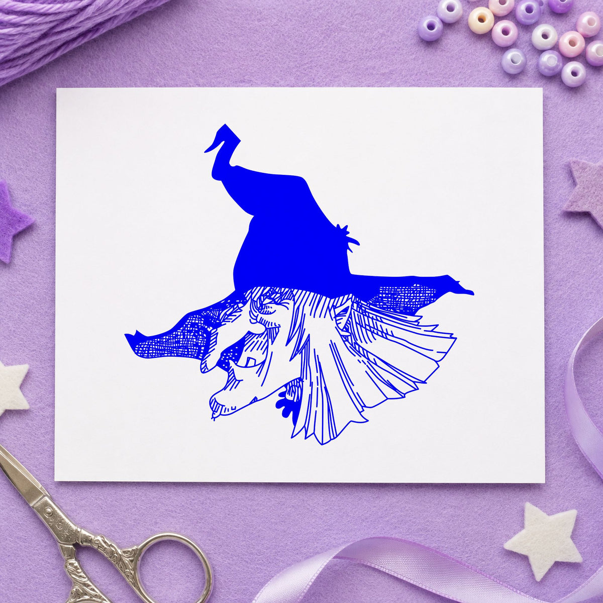 Blue spooky halloween stamp impression featuring the witch head with hat design on white paper.