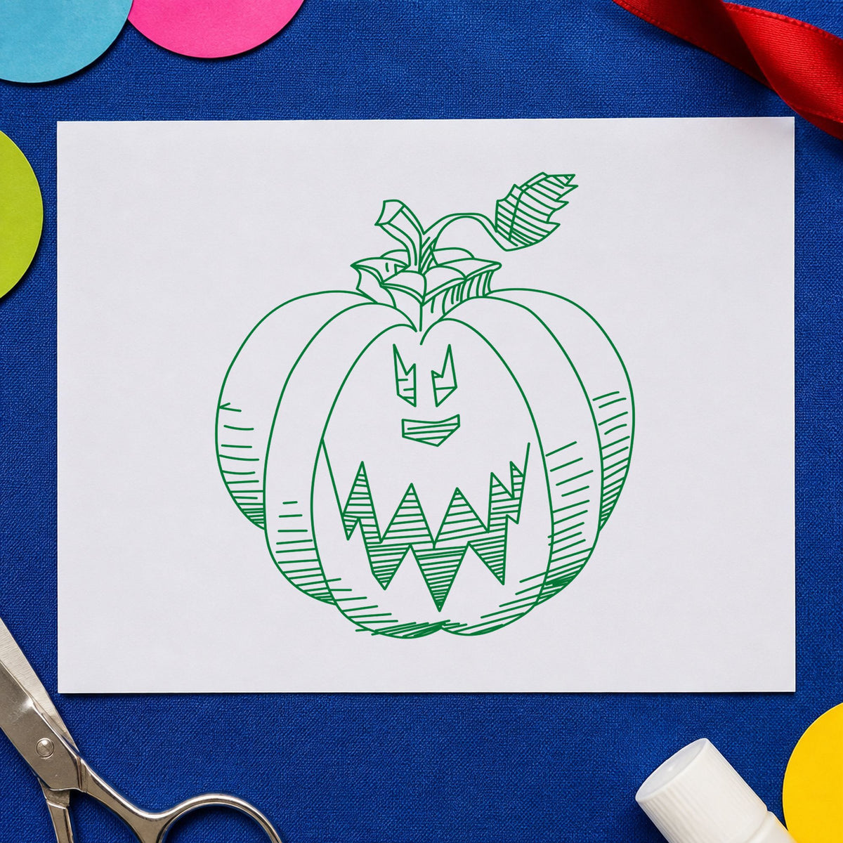 Scary Pumpkin Face Rubber Stamp impression in green ink on white paper in a styled craft setting.