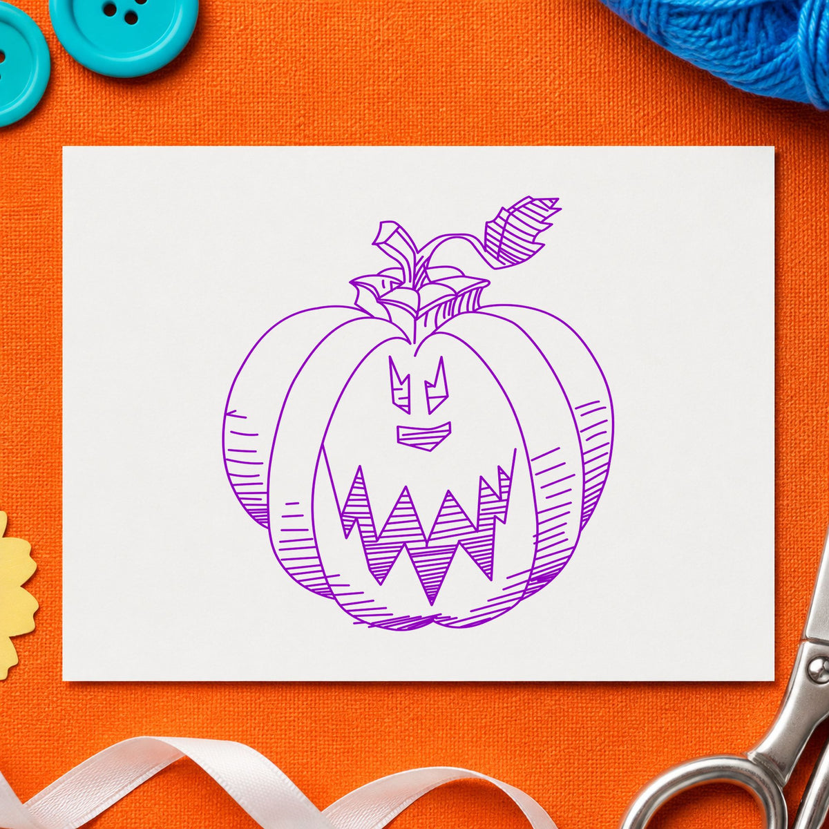 Scary Pumpkin Face Rubber Stamp impression in purple ink on white paper in a styled craft setting.