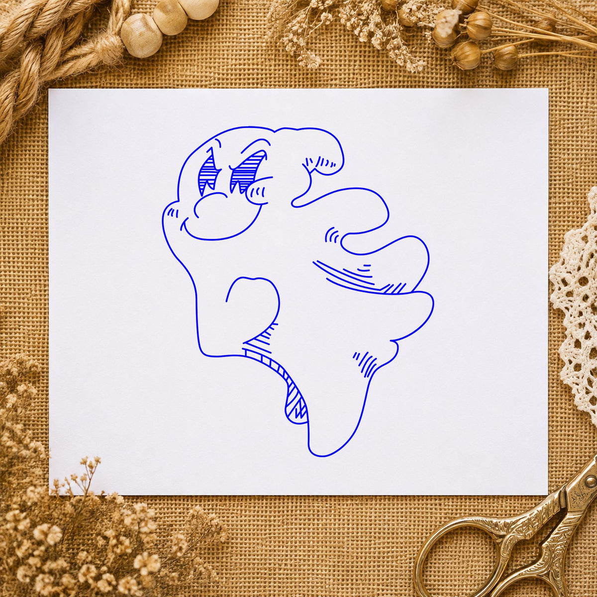 Friendly Smiling Ghost Rubber Stamp impression in blue ink on white paper in a styled craft setting.