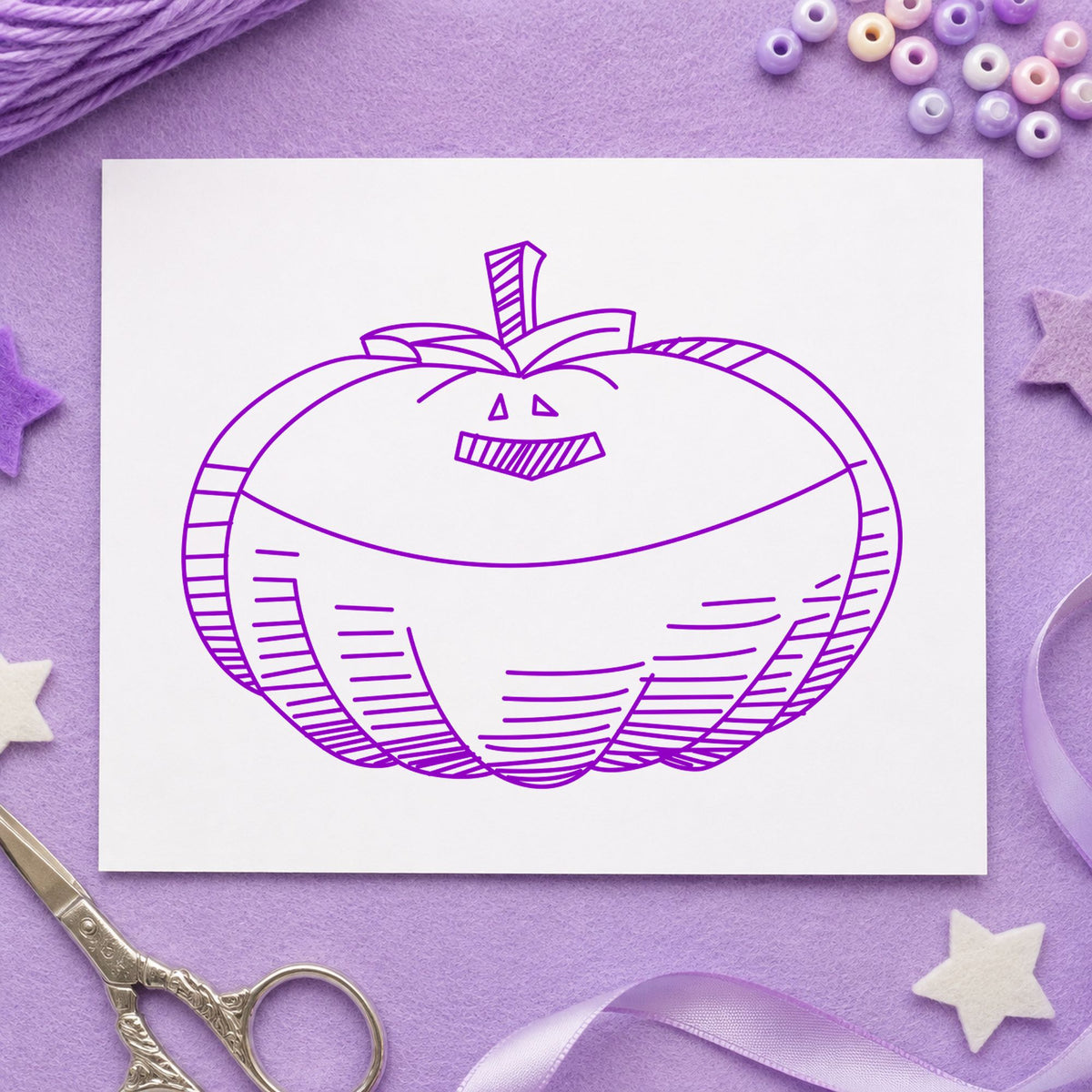 Smiling Jacko Lantern Rubber Stamp impression in purple ink on white paper in a styled craft setting.