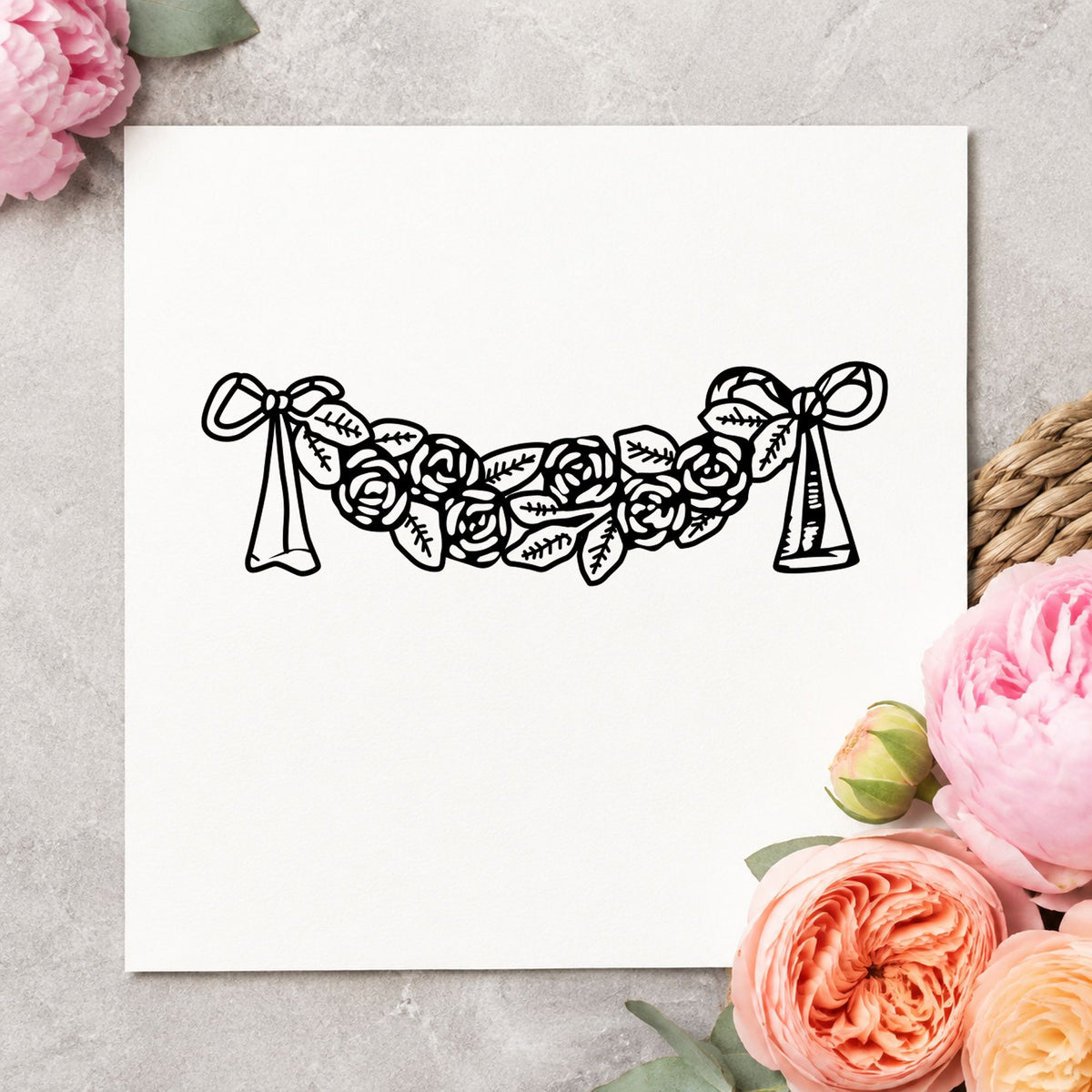 Black impression from a floral swag stamp, featuring the rose swag with bows design on white paper.