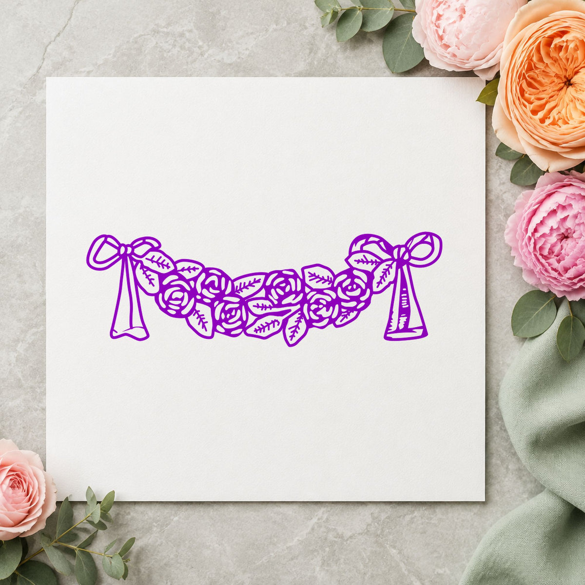 Rose Swag with Bows Rubber Stamp impression in purple ink on white paper in a styled craft setting.