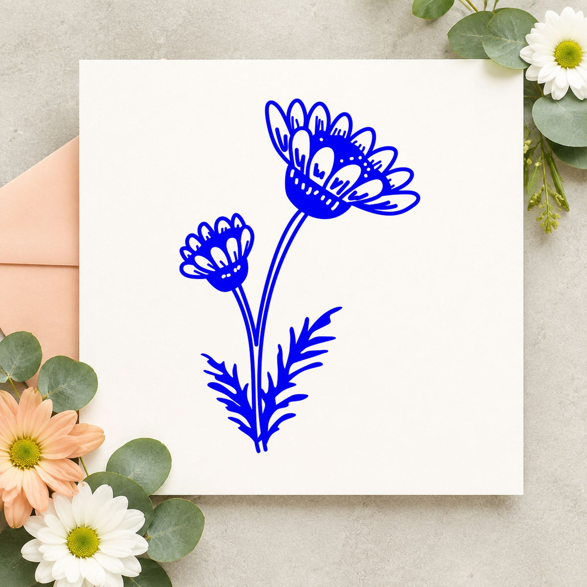 Two Daisies on a Stem Rubber Stamp impression in blue ink on white paper in a styled craft setting.