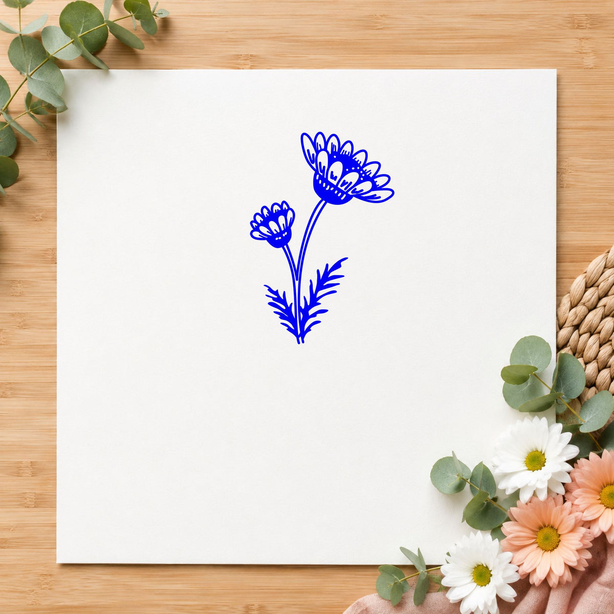 Blue botanical paper craft stamp impression featuring the two daisies on a stem design on white paper.