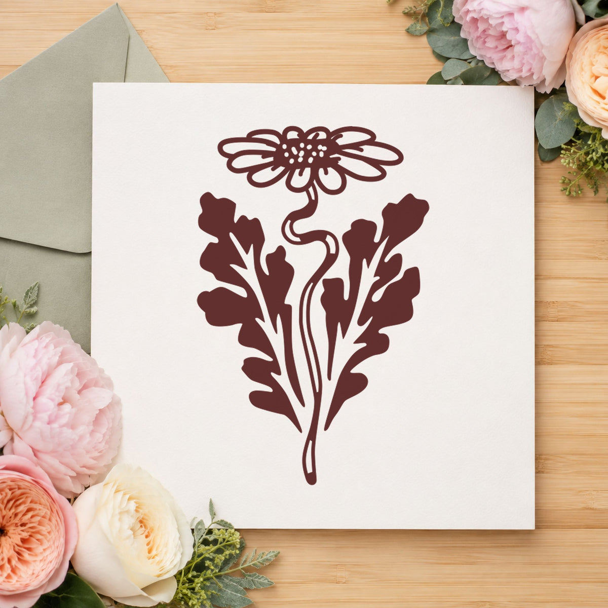 Daisy with Leaf Rubber Stamp impression in brown ink on white paper in a styled craft setting.