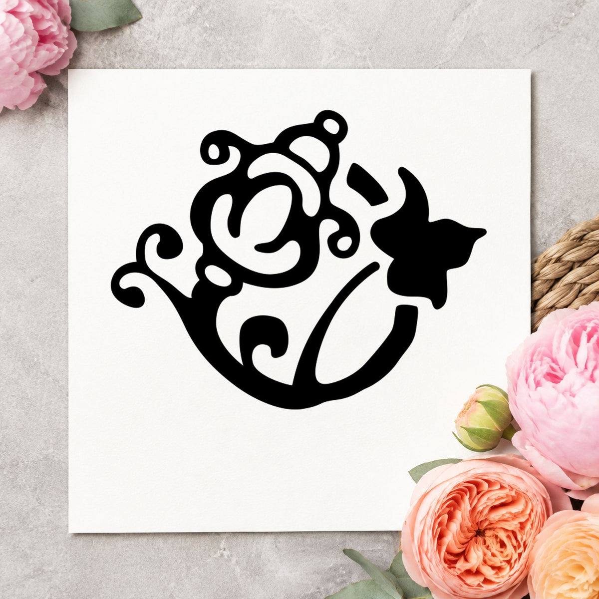 Flower and Watering Can Rubber Stamp impression in black ink on white paper in a styled craft setting.
