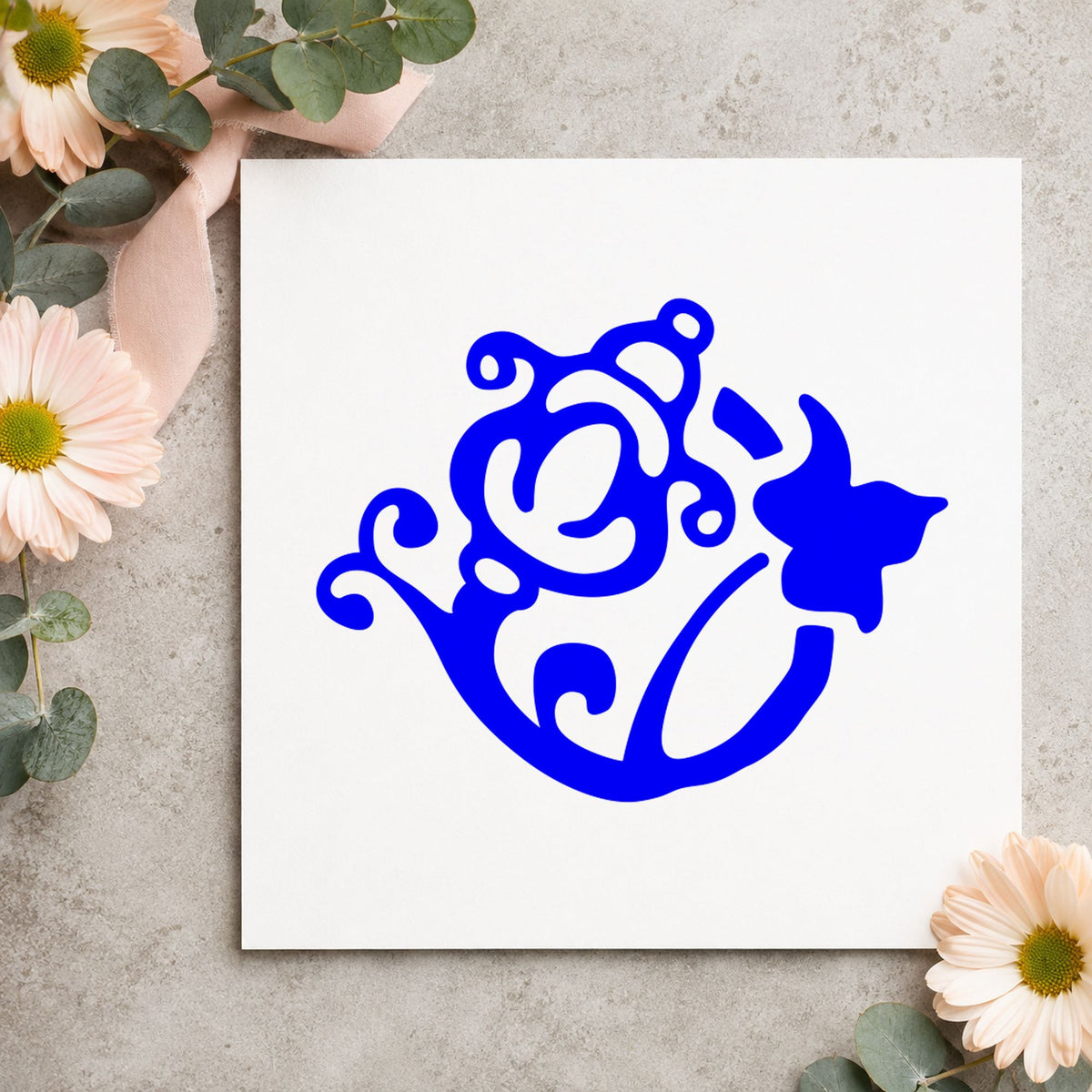 Blue spring flower craft stamp impression featuring the flower and watering can design on white paper.