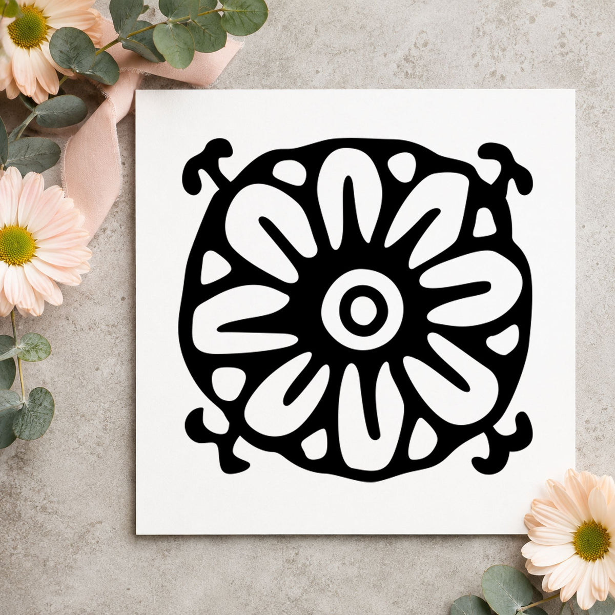 Black impression from a floral pattern stamp, featuring the square flower motif design on white paper.
