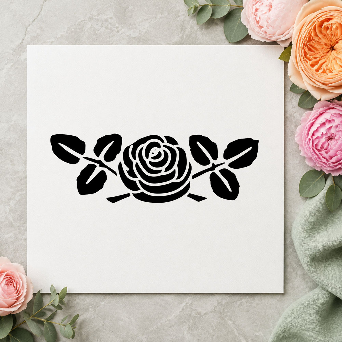 Black impression from a rose rubber stamp, featuring the rose flower large design on white paper.