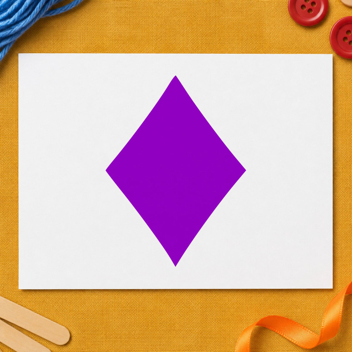Playing Card Diamond Rubber Stamp impression in purple ink on white paper in a styled craft setting.