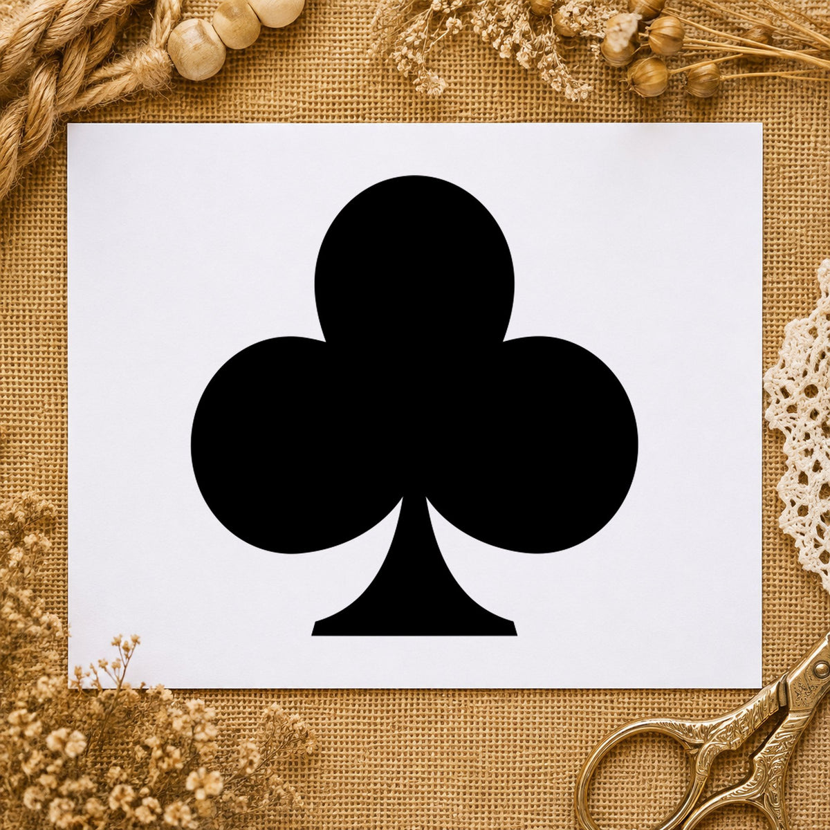 Black impression from a playing card stamp, featuring the playing card club design on white paper.