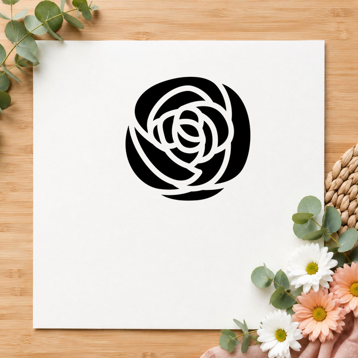 Black impression from a floral rubber stamp, featuring the single solid flower design on white paper.