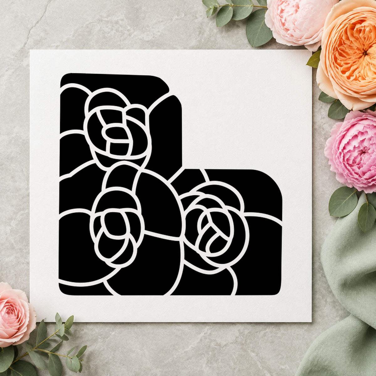 Black impression from a floral corner stamp, featuring the three solid flowers corner design on white paper.