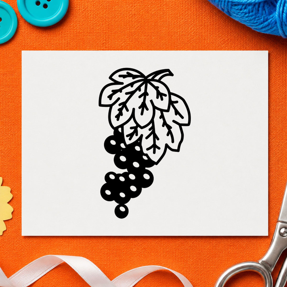 Grape Bunch on Vine Rubber Stamp impression in black ink on white paper in a styled craft setting.