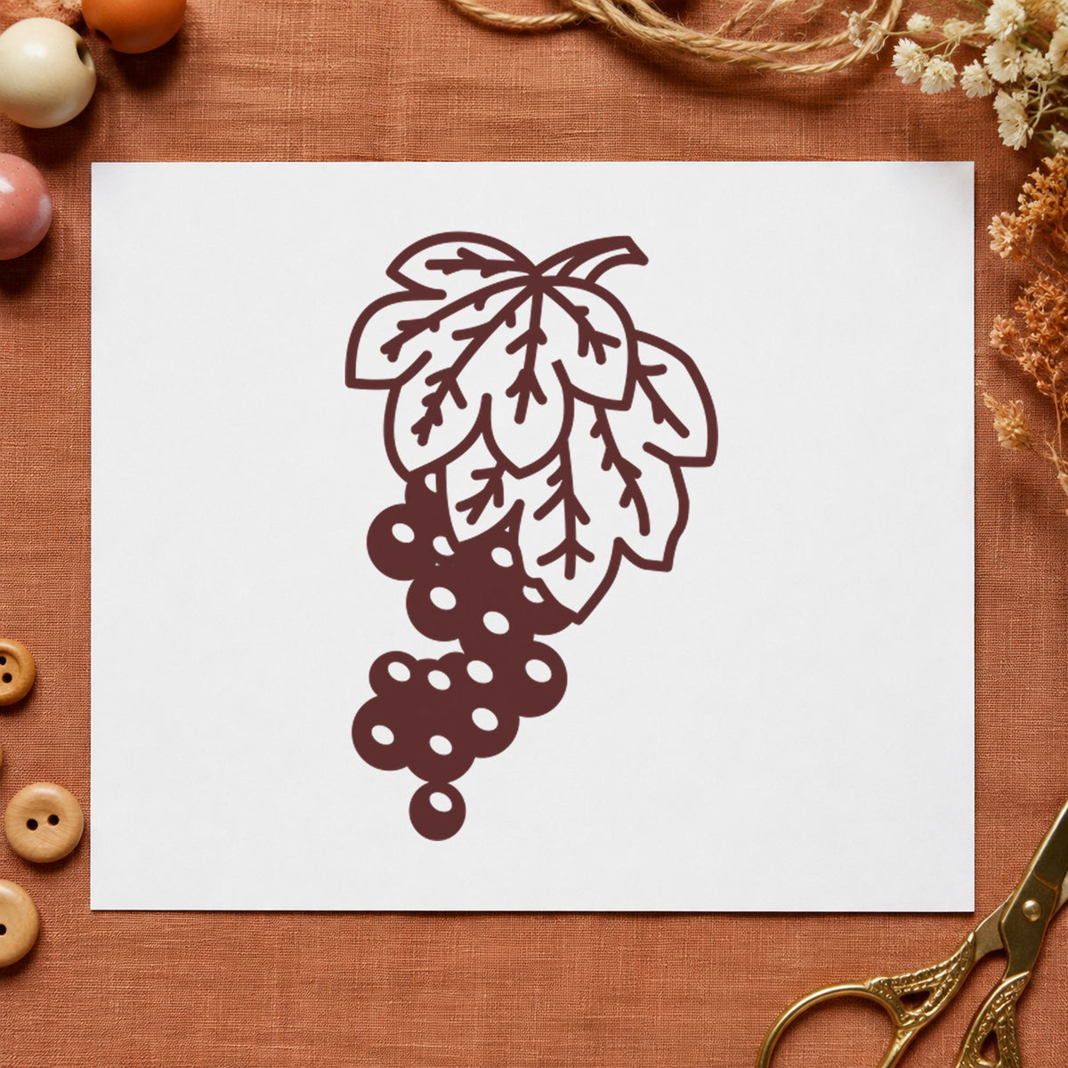 Grape Bunch on Vine Rubber Stamp impression in brown ink on white paper in a styled craft setting.