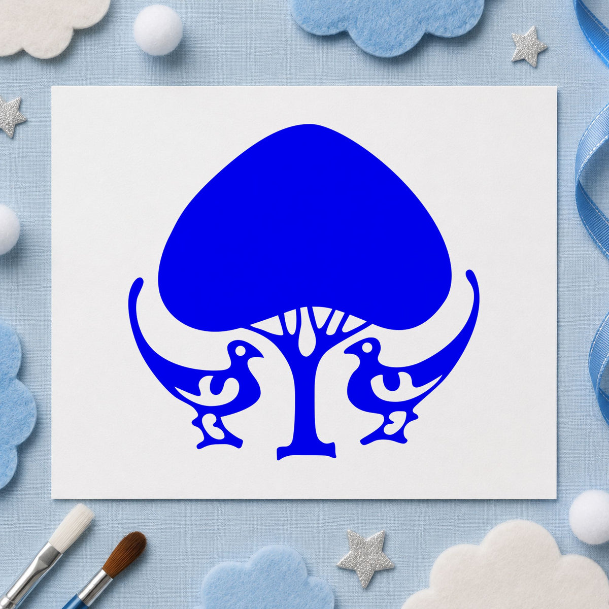 Blue woodland craft stamp impression featuring the leafy tree and birds design on white paper.