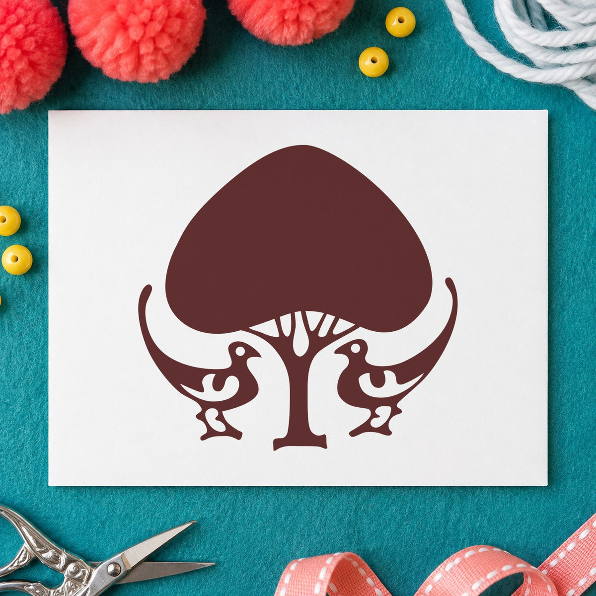 Leafy Tree and Birds Rubber Stamp impression in brown ink on white paper in a styled craft setting.