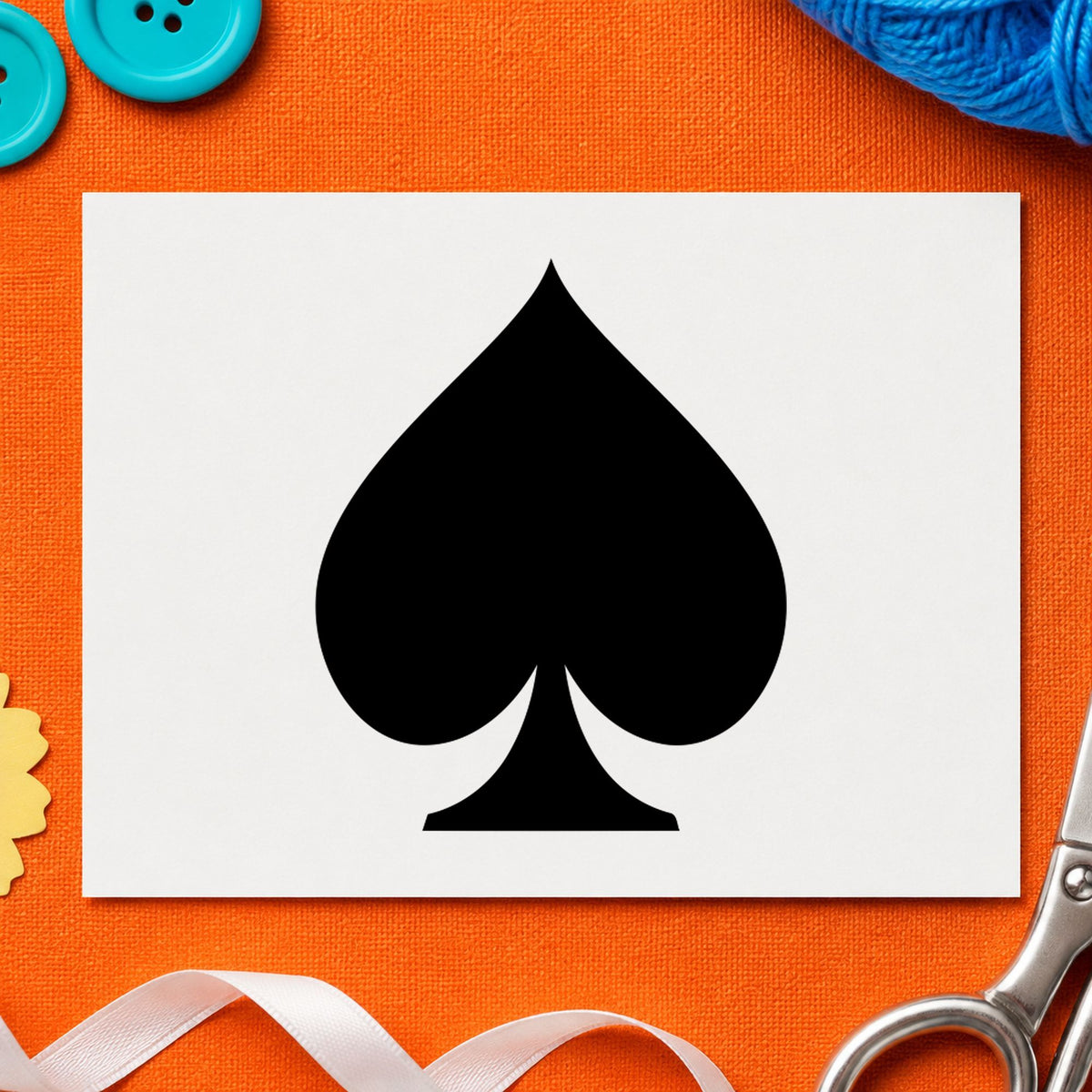 Playing Card Spade Rubber Stamp impression in black ink on white paper in a styled craft setting.