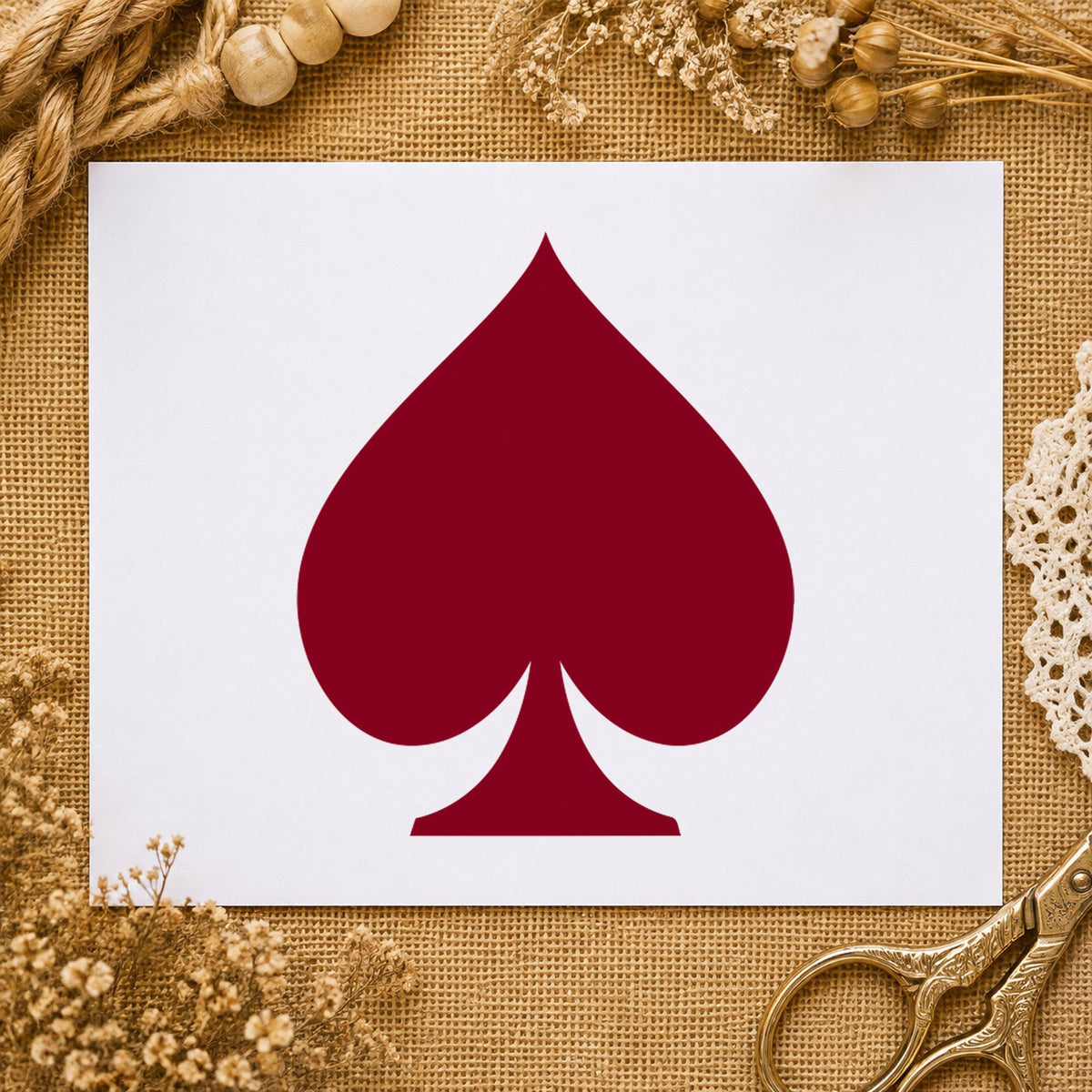 Playing Card Spade Rubber Stamp impression in burgundy ink on white paper in a styled craft setting.