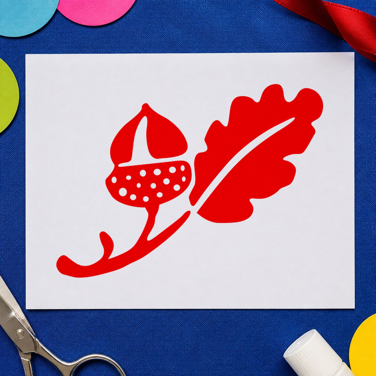Solid Acorn and Leaf Rubber Stamp impression in red ink on white paper in a styled craft setting.