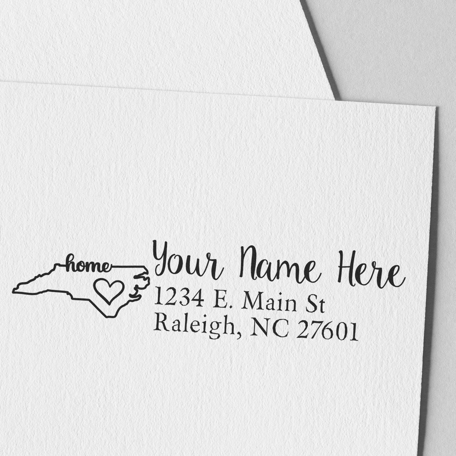 Personalized North Carolina return address rubber stamp with home icon, custom name, and mailing address on envelope.