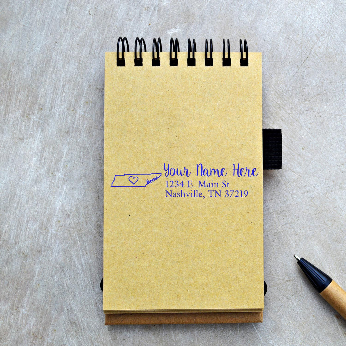 Custom rubber stamp return address imprint on notebook with Tennessee home icon and personalized name, street address, and city.