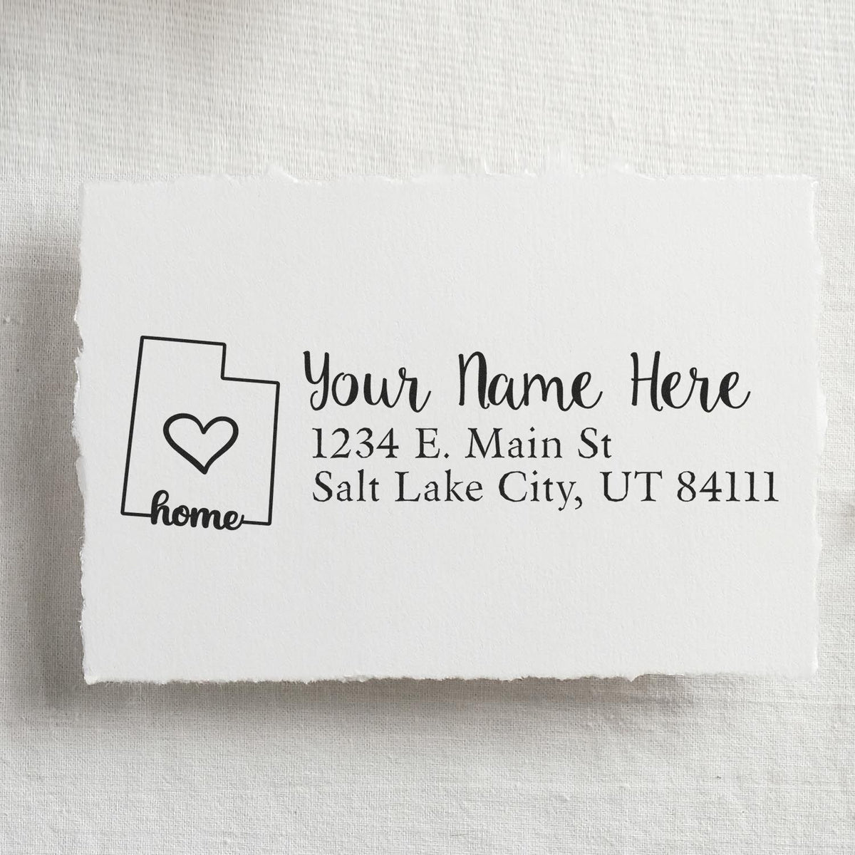 Custom home address rubber stamp with state outline and heart for personalized return address labeling on envelopes and stationery.