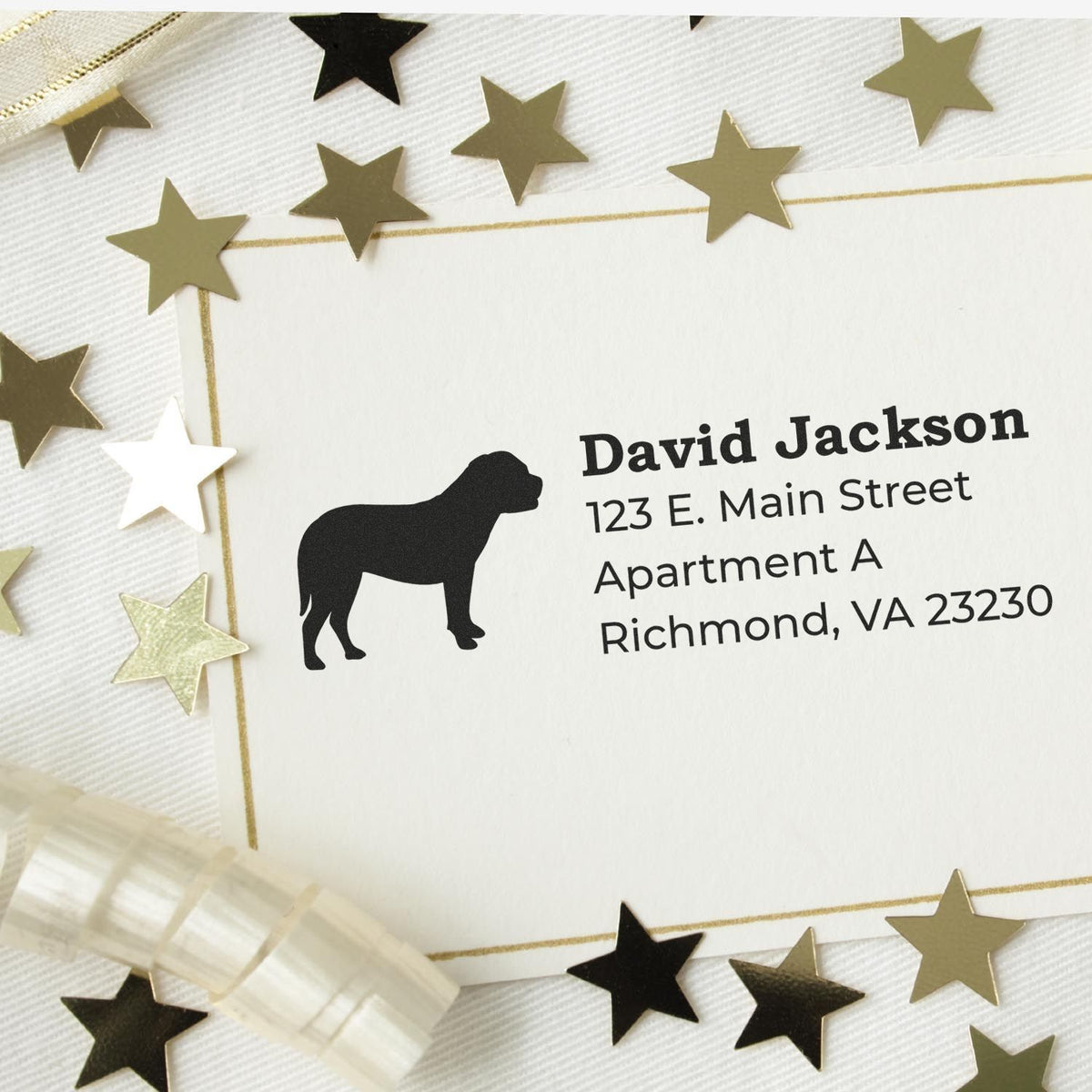 Personalized dog return address rubber stamp on decorative envelope with gold star confetti.