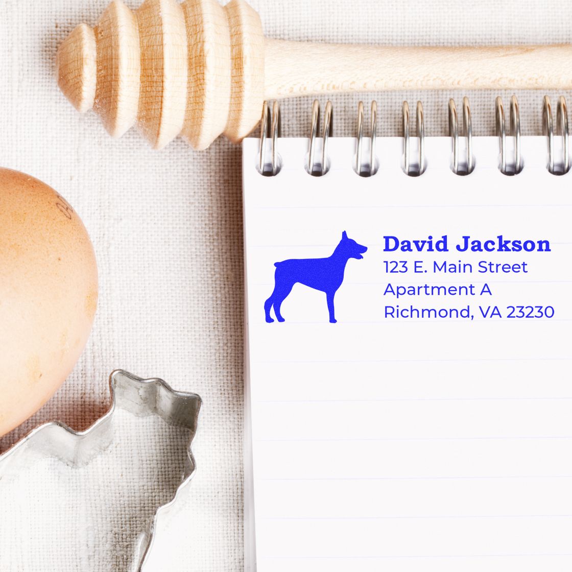 Custom dog return address rubber stamp impression on a notebook, showing personalized mailing details for David Jackson in blue.