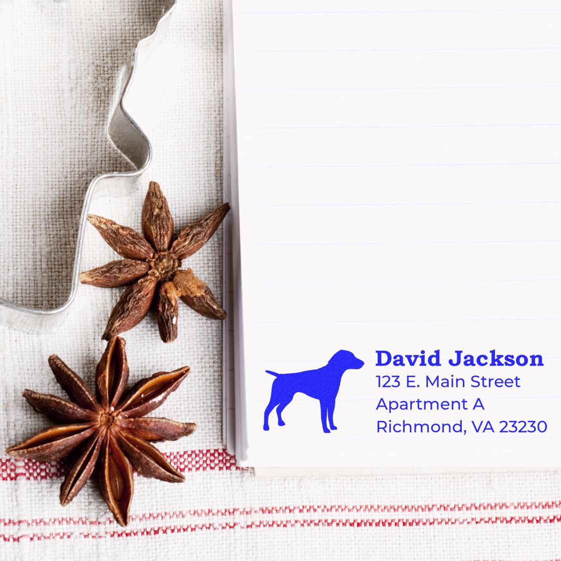 Custom dog address rubber stamp on stationery, featuring a blue dog silhouette and personalized return address for mail.