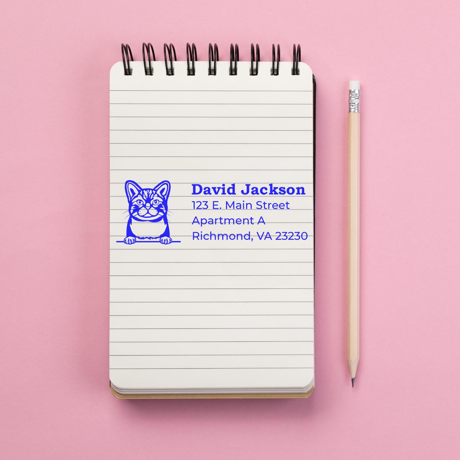 Custom cat address rubber stamp with name and mailing address on a notebook page, ideal for personalized stationery.