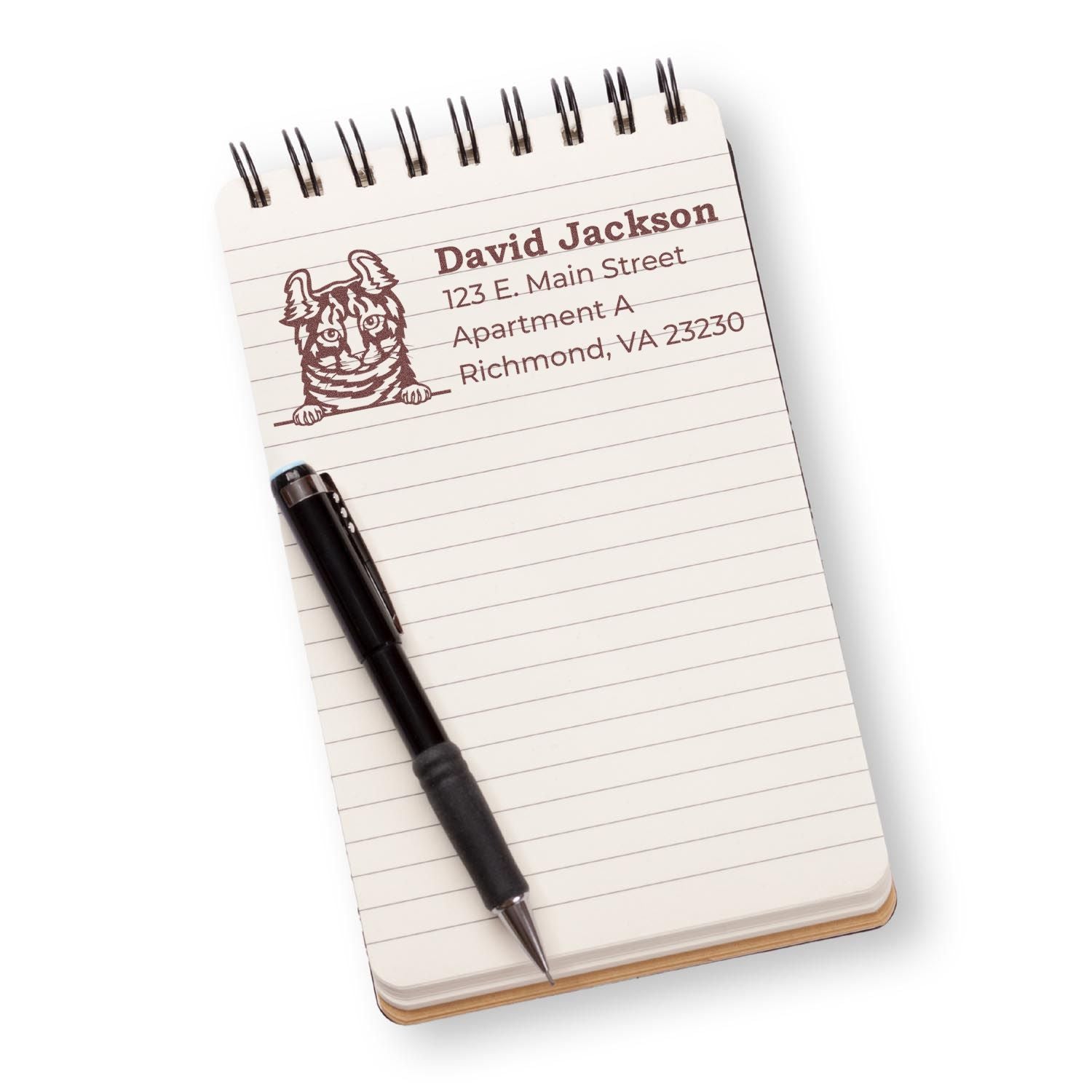 Personalized rubber address stamp with cat design on notepad, showing name and address for mailing.