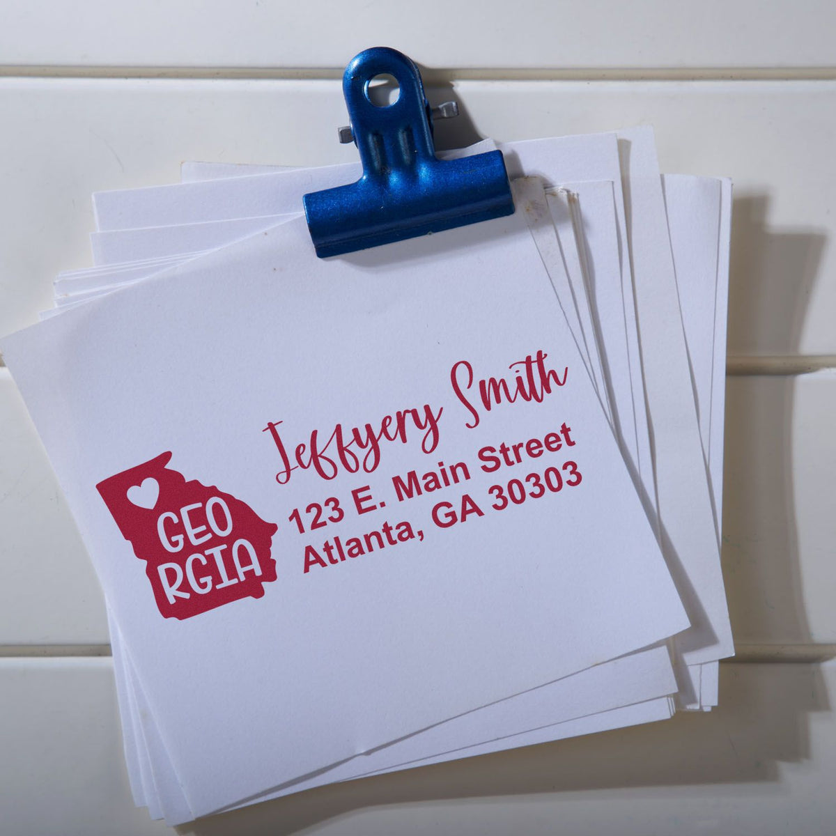 Custom return address rubber stamp on stacked envelopes, featuring Jeffery Smith's Georgia mailing address in Atlanta.