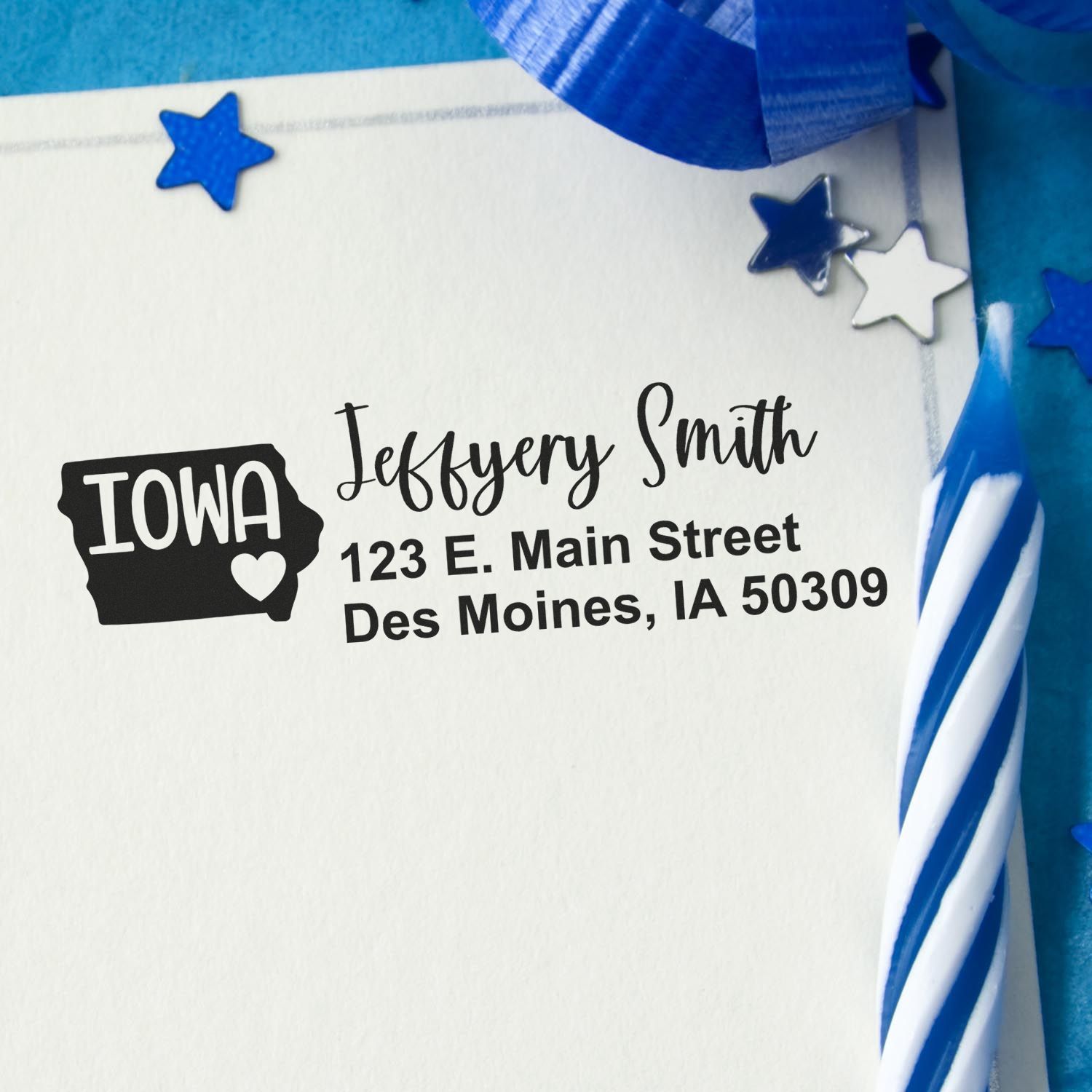 Custom Iowa return address rubber stamp on envelope with name, Des Moines address, and patriotic blue star accents.