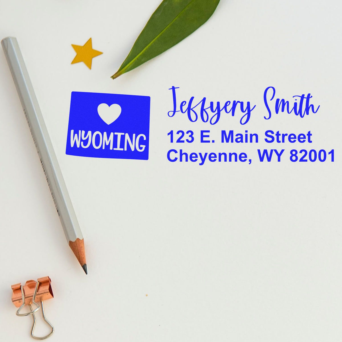 Personalized return address rubber stamp with Wyoming heart logo, name, and address for mailing and branding.