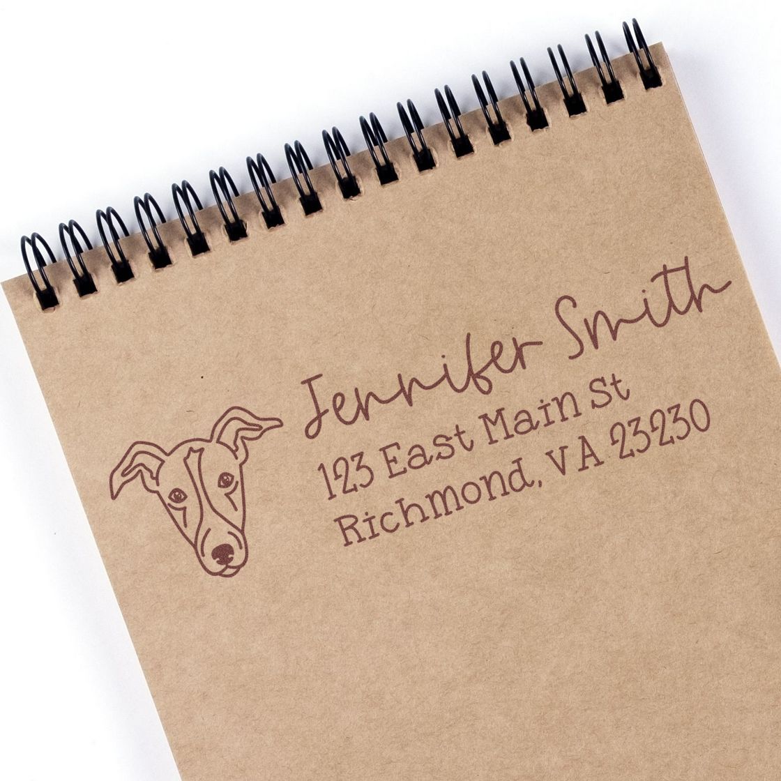 Custom return address rubber stamp with dog logo for Jennifer Smith, Richmond, VA, stamped on kraft notebook paper.