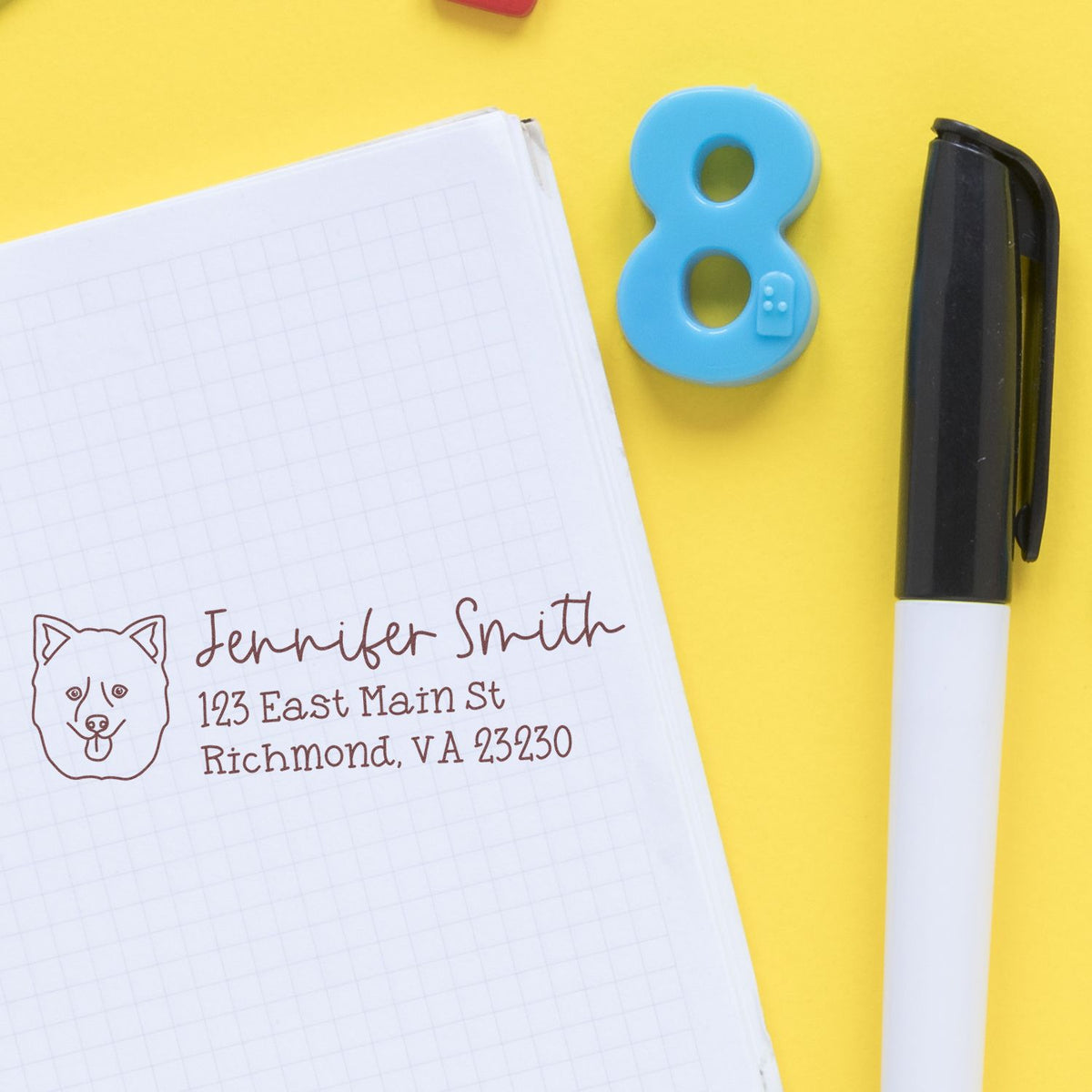 Custom dog return address rubber stamp on notebook, featuring name and address for personalized mailing and stationery use.