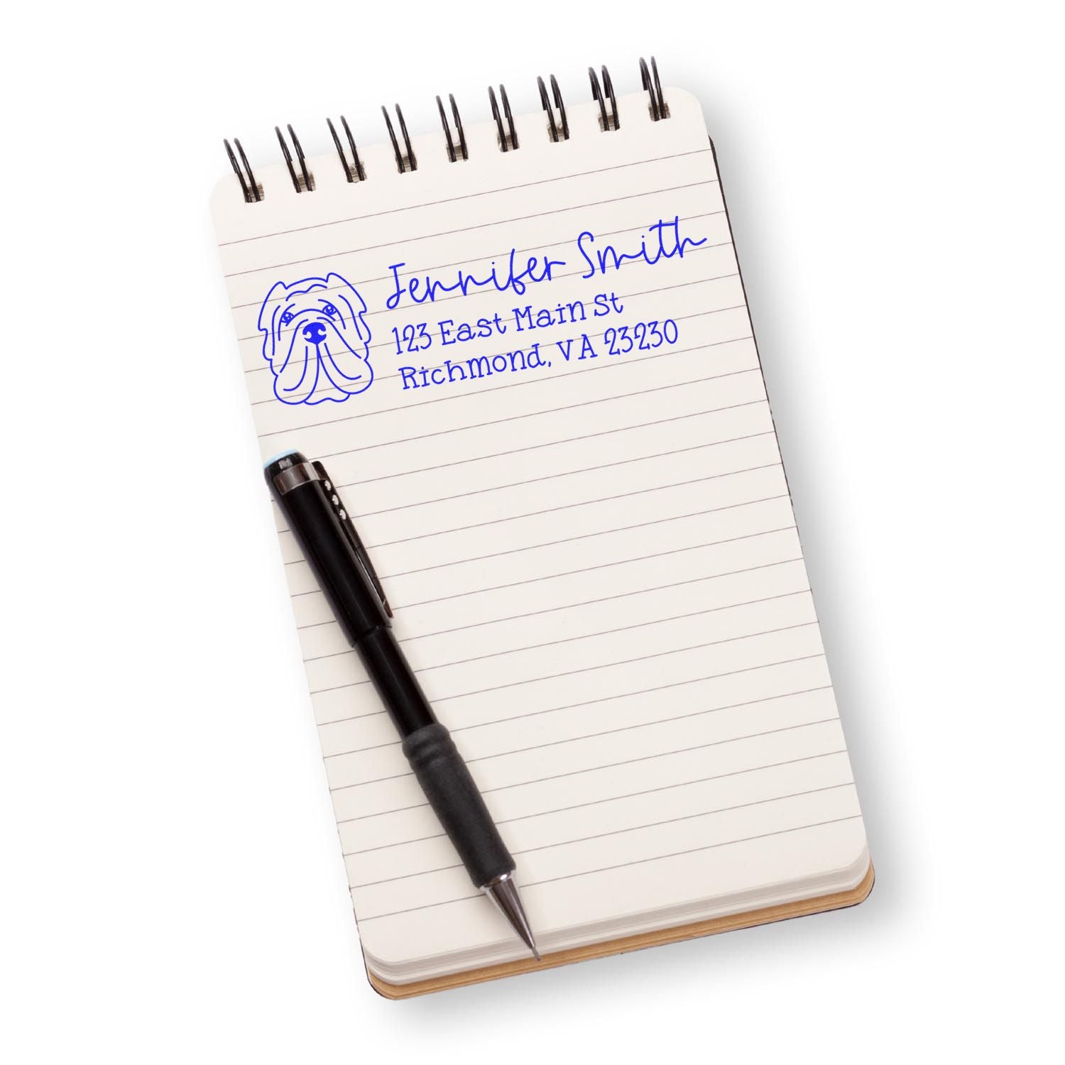Custom rubber address stamp with dog logo, name, and Richmond, VA address stamped in blue on a notebook.