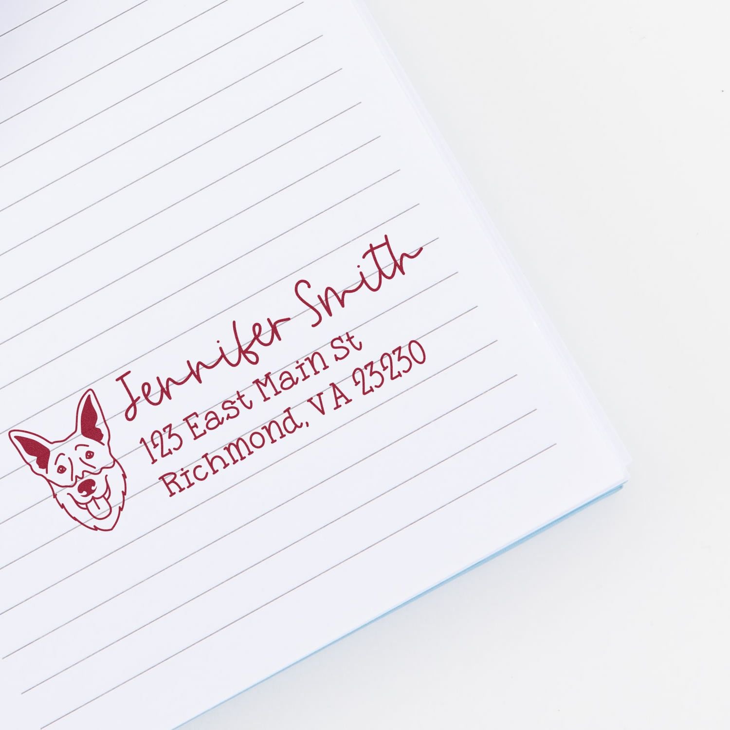 Custom rubber address stamp with dog logo for Jennifer Smith, showing name and Richmond, VA mailing details on lined paper.