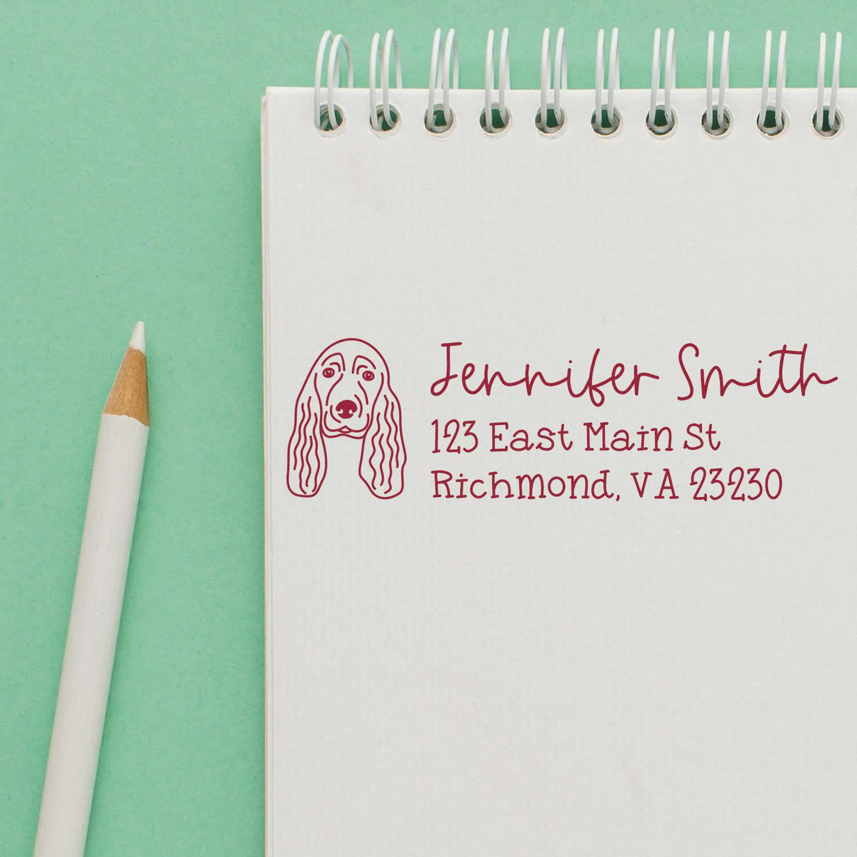 Personalized return address rubber stamp with dog portrait for Jennifer Smith, Richmond, VA, on a notebook.