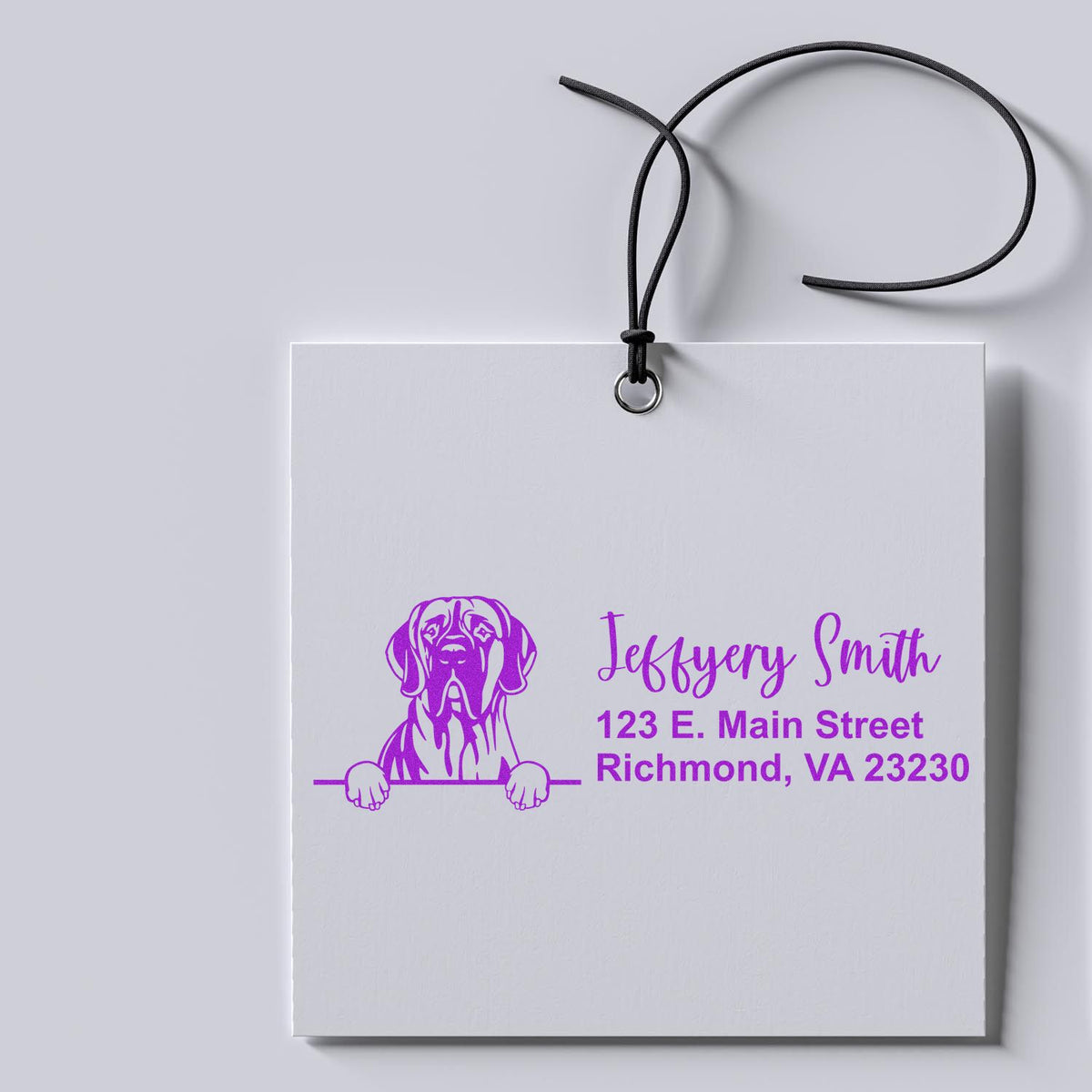 Personalized pet business rubber stamp on a gift tag, featuring a dog logo, name, and address in purple for branded packaging.