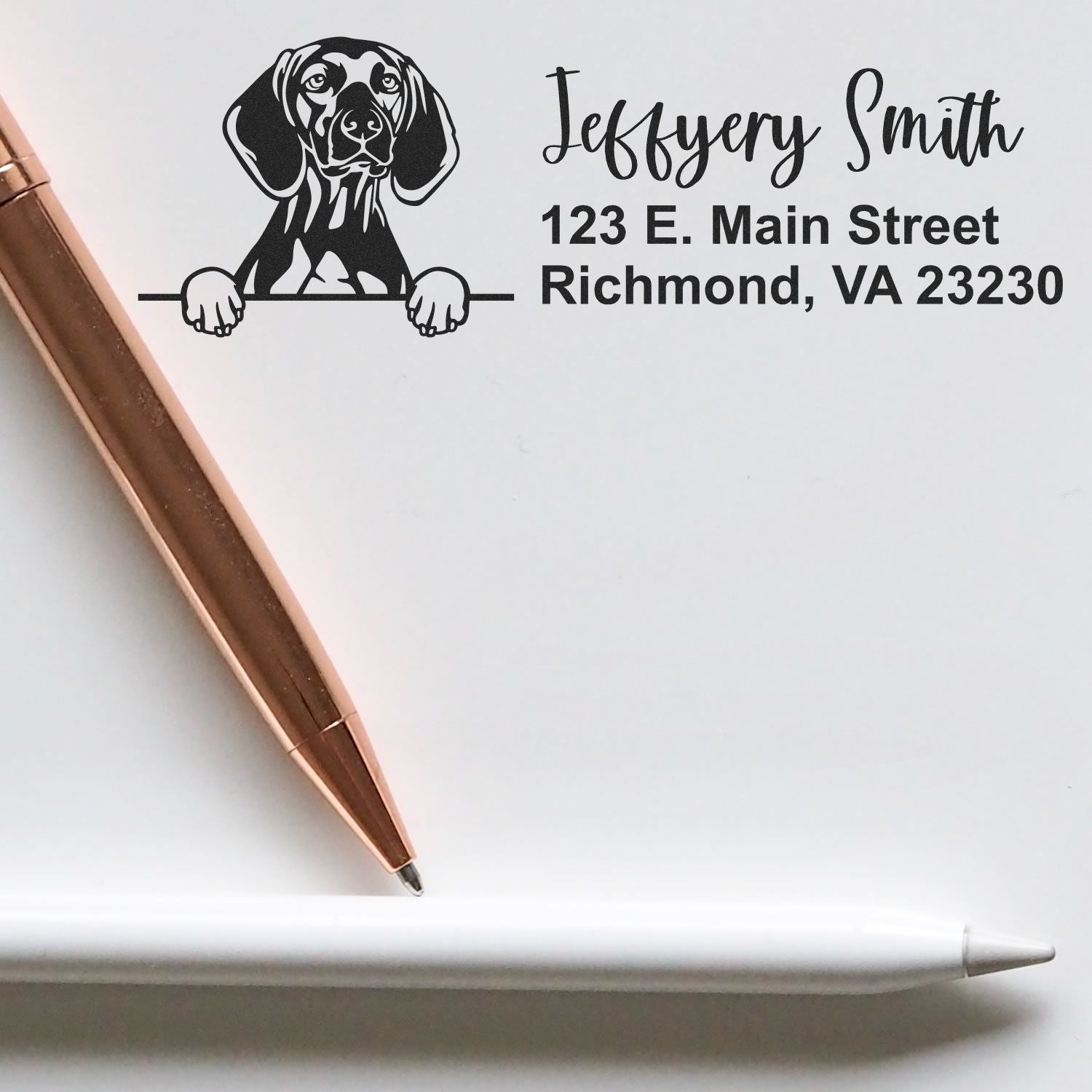 Custom dachshund return address rubber stamp with name and Richmond, VA address, shown beside a pen on paper.
