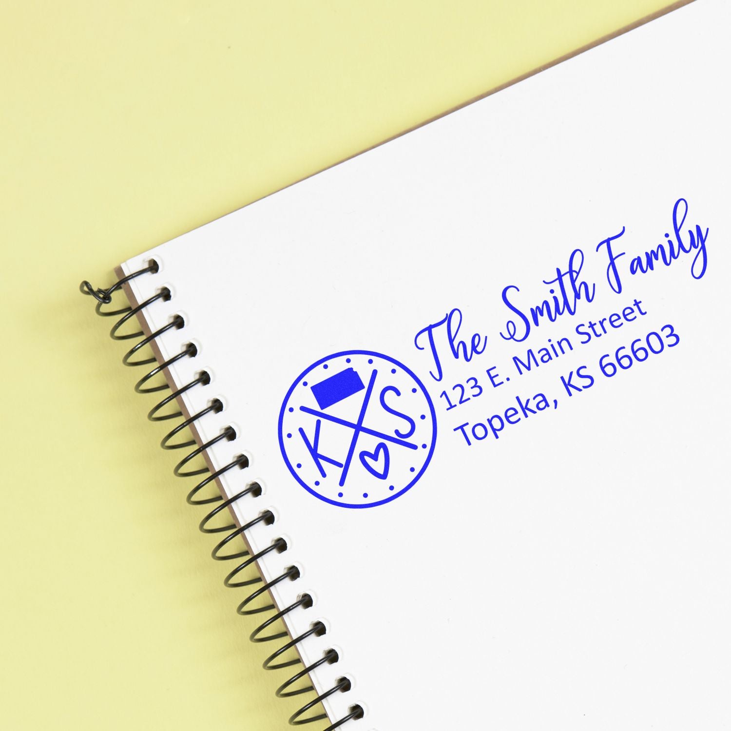 Custom rubber return address stamp for The Smith Family, shown in blue on a spiral notebook cover.