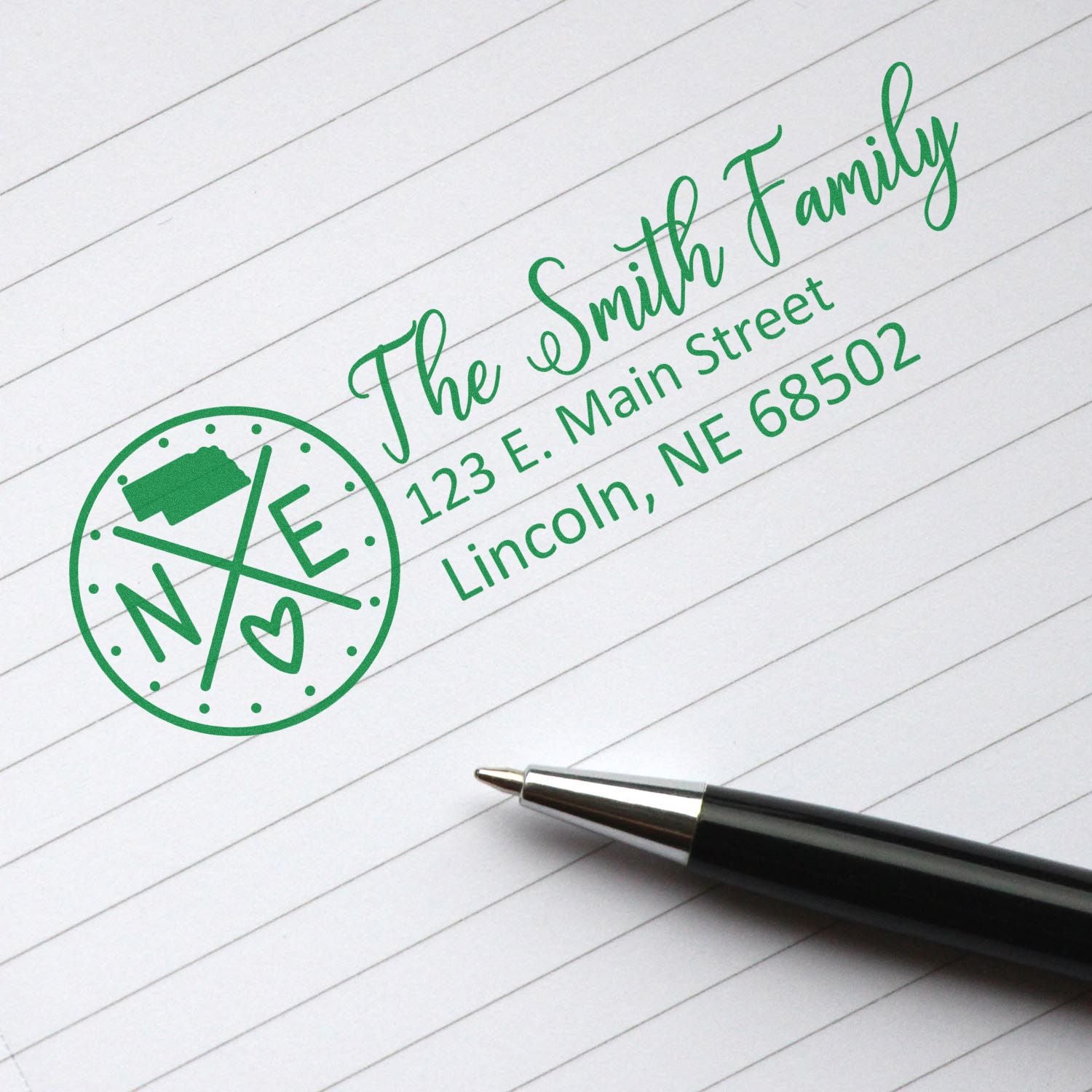 Custom return address rubber stamp for The Smith Family, with green name and address imprint on lined paper.
