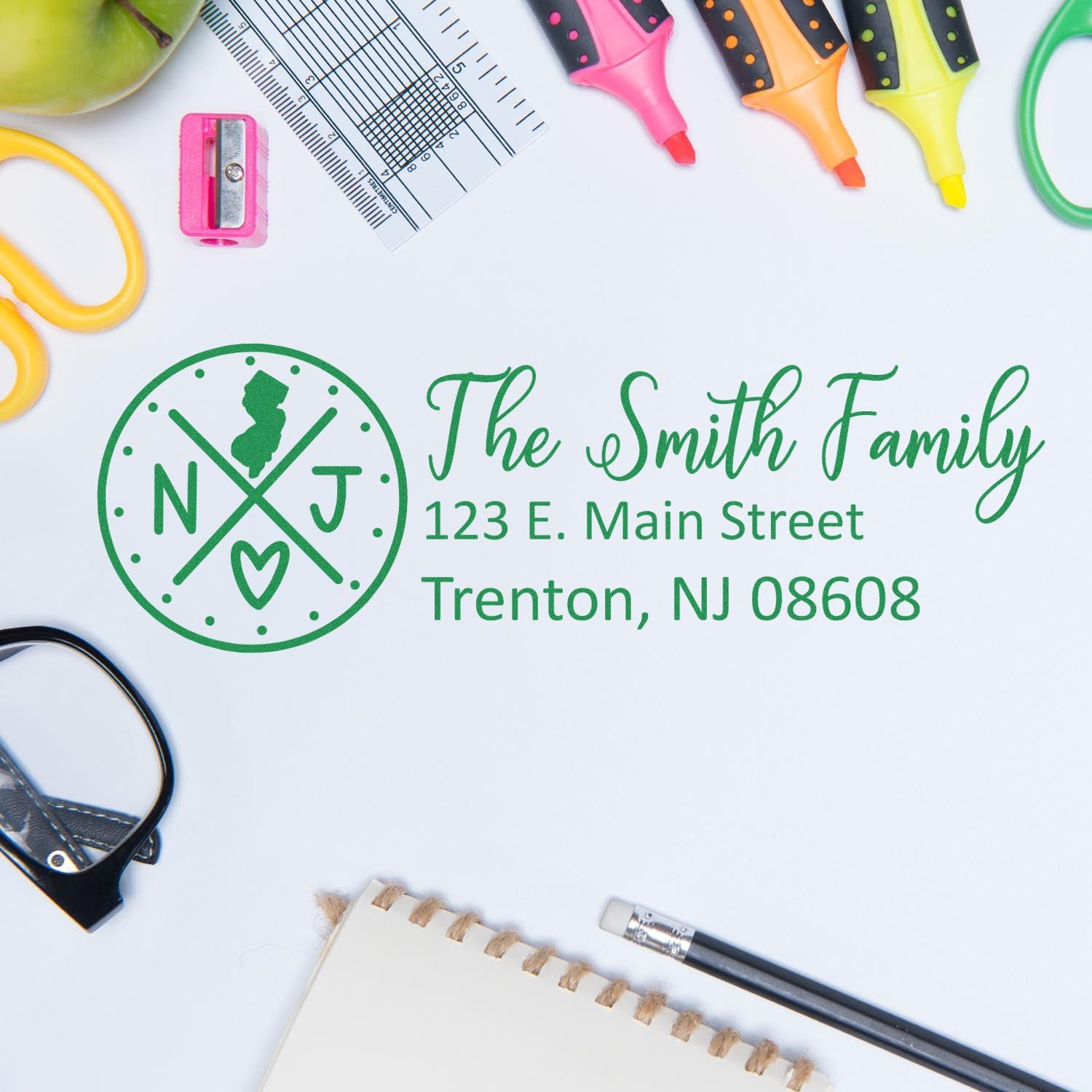 Custom return address stamp with family monogram, name, and address, styled with colorful stationery tools.