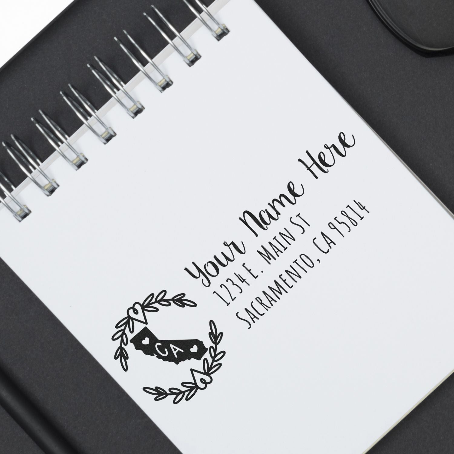 Custom return address rubber stamp with California state design and floral wreath for personalized mailing.