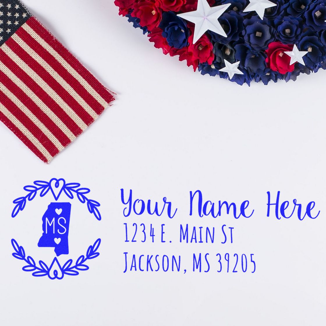 Personalized Mississippi return address rubber stamp in blue ink, shown with patriotic red, white and blue decor.