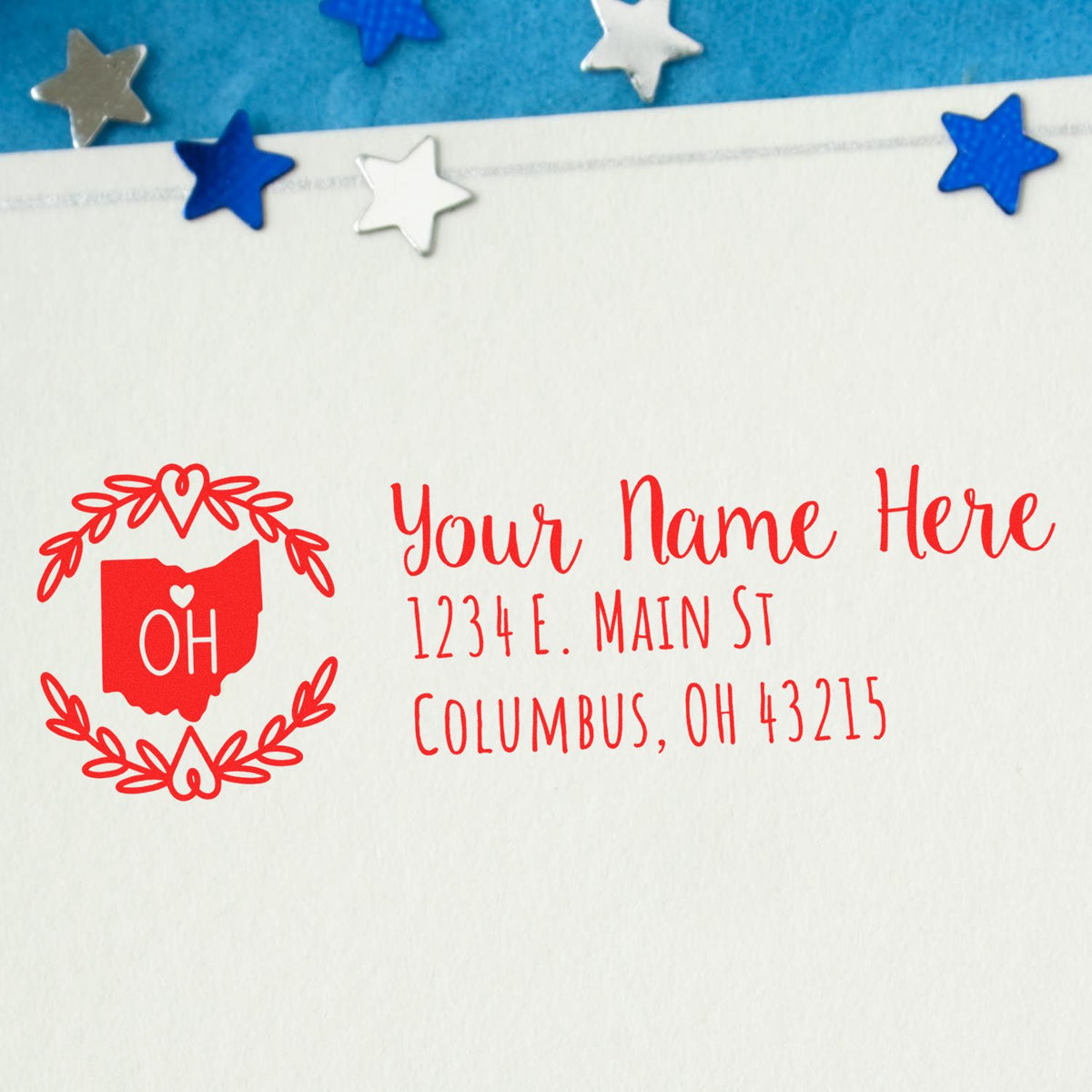 Custom red Ohio return address rubber stamp with floral wreath and personalized address on envelope.